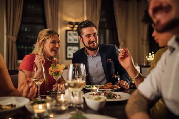 Guests toasting glasses around a dinner table